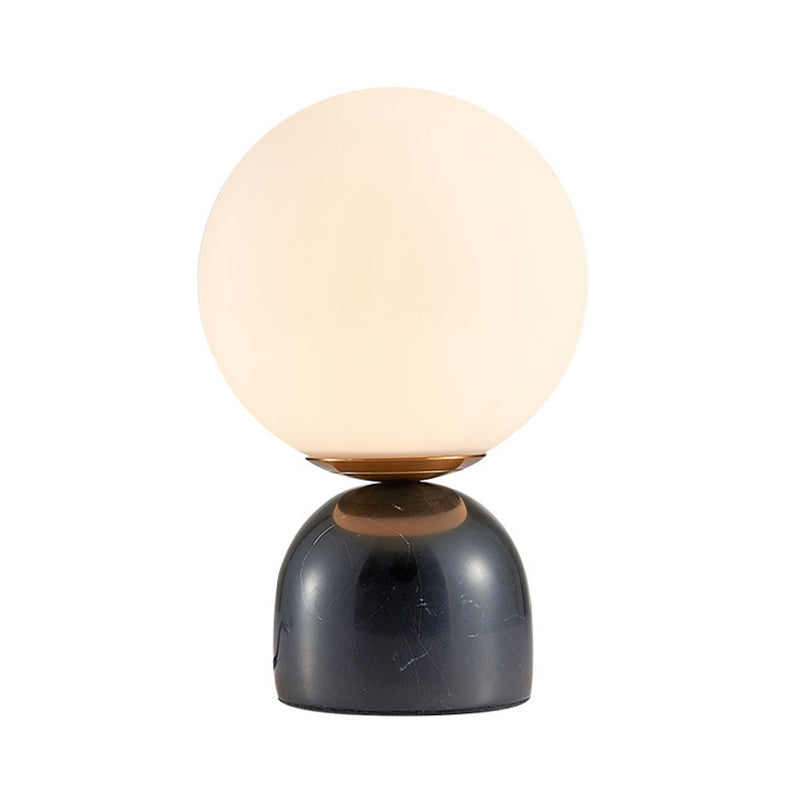 Bordslampa med glasglob och stenfot